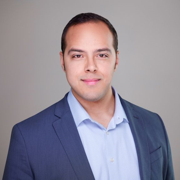 Matthew Matias wearing a navy jacket and light blue shirt